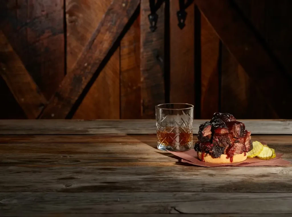 Burnt ends burger, pickles, and old-fashioned whiskey.