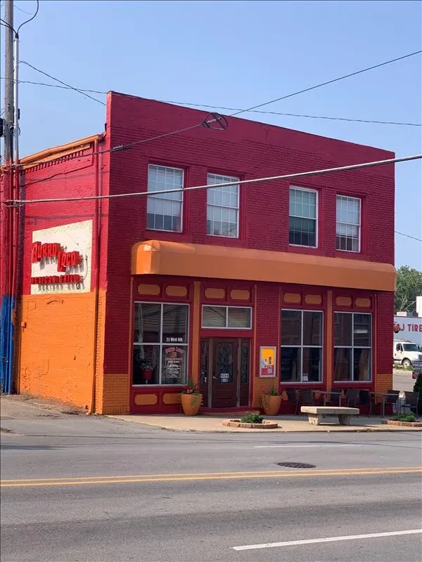 Exterior of Horro Taco, a two-story red and orange Mexican restaurant.