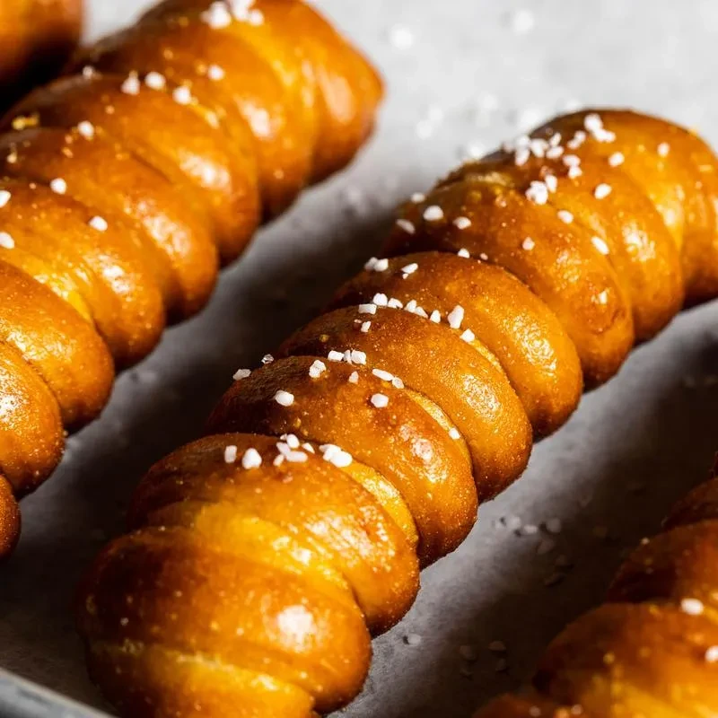 Close-up of golden-brown pretzel twists generously sprinkled with salt.