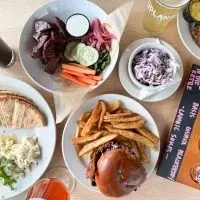 Flat-lay of a diverse meal spread, including a burger and drinks.