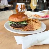 Burger, chips, and Upland Brewing Co. drinks on a restaurant table.