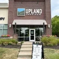 Exterior of Upland Brewing Co. brick building with landscaping.