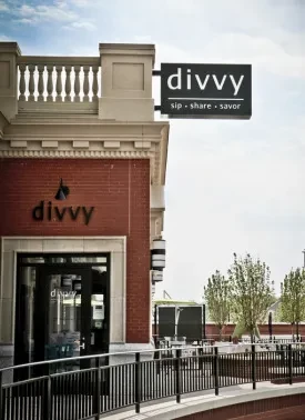 Red brick Divvy restaurant with glass doors and outdoor patio.