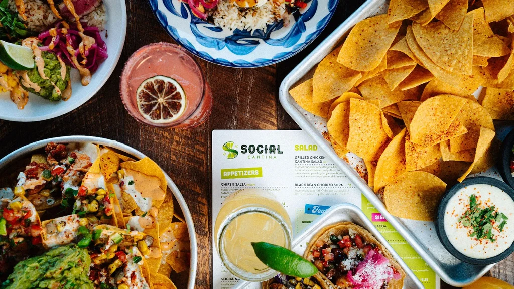 Flat-lay of Mexican dishes, drinks, and a Social Cantina menu.