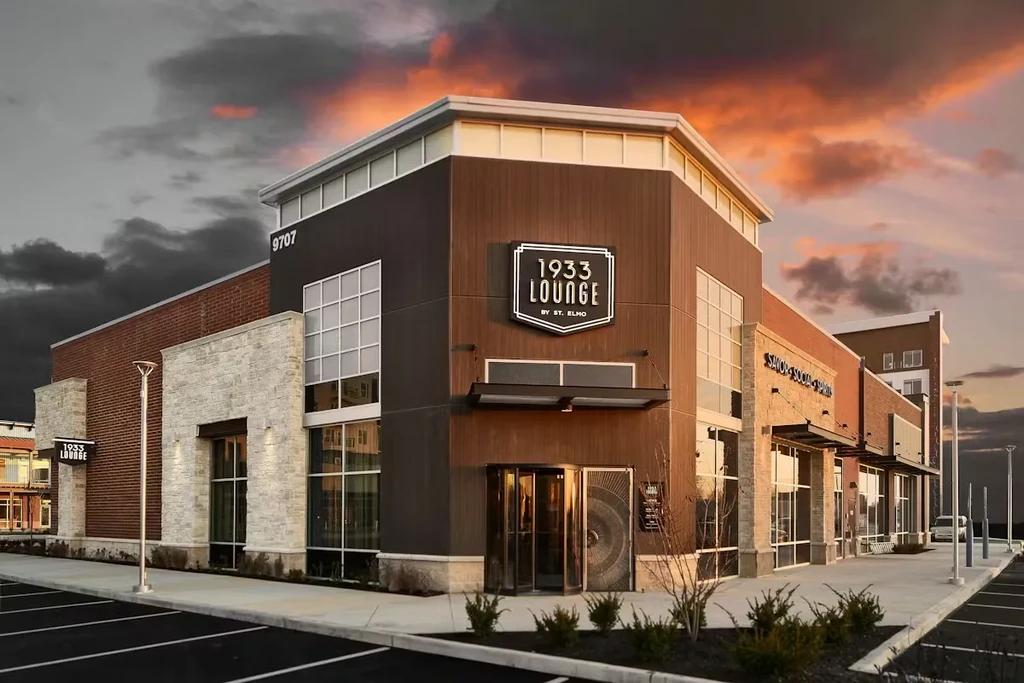 Modern 1933 LOUNGE BY ST. ELMO building exterior, dramatic dusk sky.