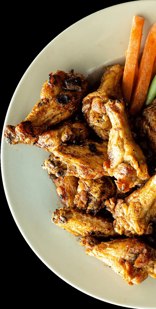 Crispy golden-brown chicken wings with carrot and celery sticks.