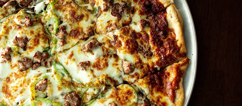 Baked half-and-half pizza: sausage/peppers, cheese, and plain sauce.