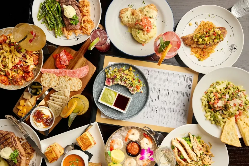 Grindstone Public House table laden with diverse gourmet food and drinks.