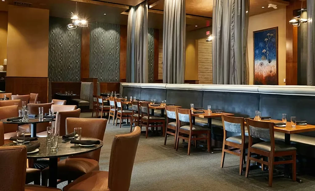 Empty, upscale restaurant interior showcasing diverse seating and warm decor.