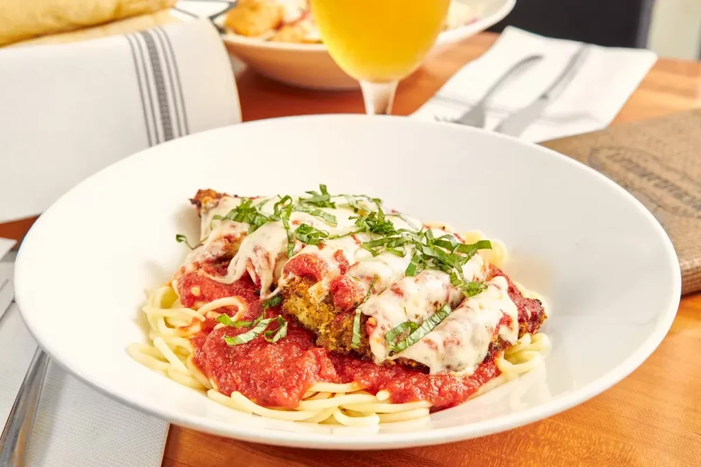 Spaghetti with chicken or eggplant parmesan, marinara, mozzarella, basil, restaurant.