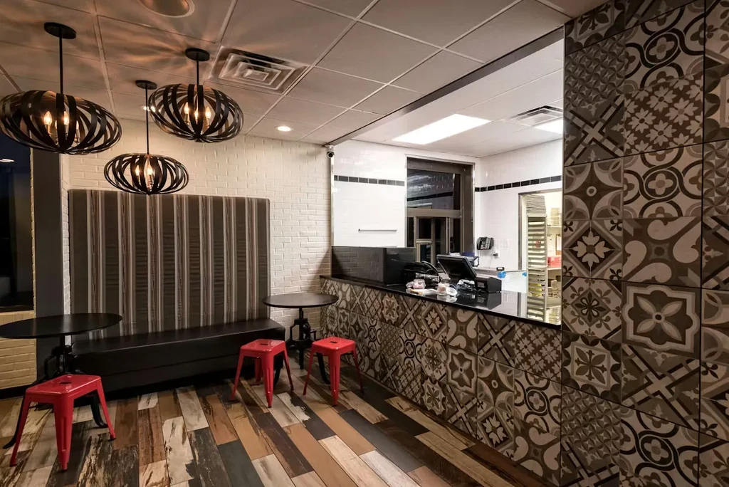 Modern cafe interior with striped bench seating and patterned tile counter.