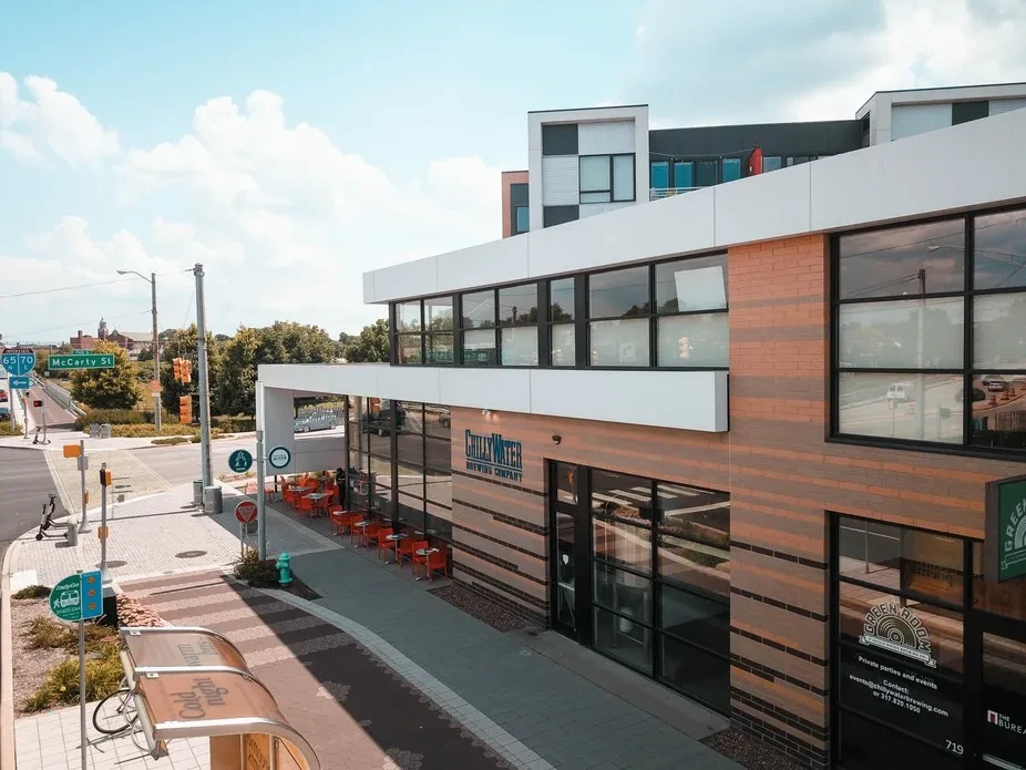 Modern Chilly Water Brewing Company building with patio at sunny intersection.