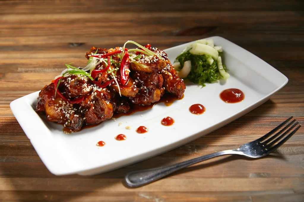 Glazed chicken wings with sesame, chili, scallions, and green salad.