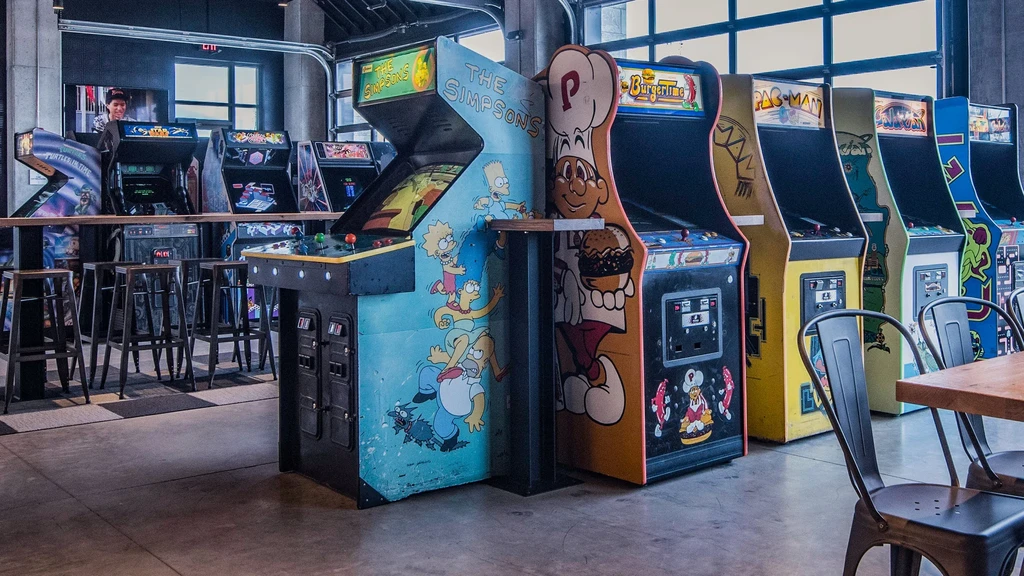 Classic arcade cabinets: Pac-Man, Simpsons, TMNT in a retro bar.