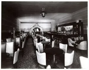 Vintage black and white photo of an empty restaurant bar interior.