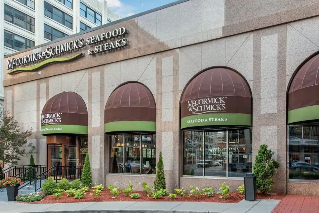 Exterior of McCormick & Schmick's Seafood & Steaks restaurant, stone facade, awnings.