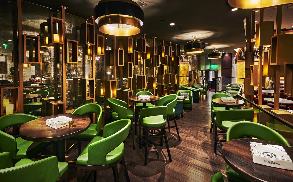 Restaurant bar: dark wood, lime green chairs, Rocky Patel ashtray.