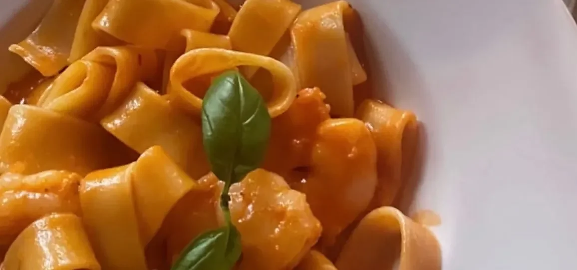 Calamarata pasta with shrimp in tomato cream sauce topped with basil