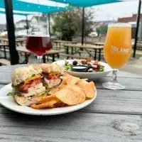 Outdoor meal: Club sandwich, chips, salad, and Midland beer.