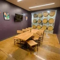 Rustic modern private dining room with long table and barrel wall.