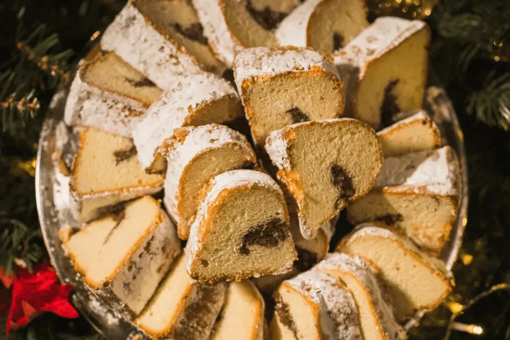 Powdered sugar-dusted sweet bread slices on a festive Christmas platter.