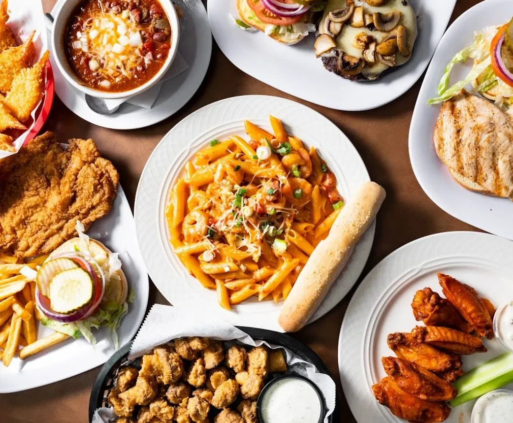 Vibrant flat lay of diverse comfort food dishes from a diner.