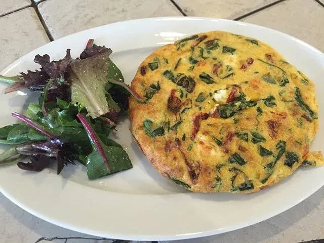Overhead view of an omelet or frittata and a fresh side salad.