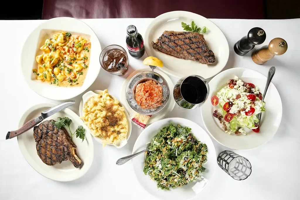 Overhead shot of a restaurant table laden with diverse food and drinks.