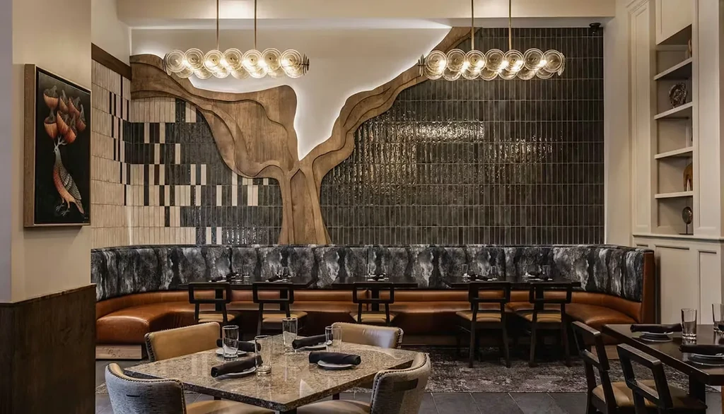 Modern restaurant dining area with curved booth and artistic decor.