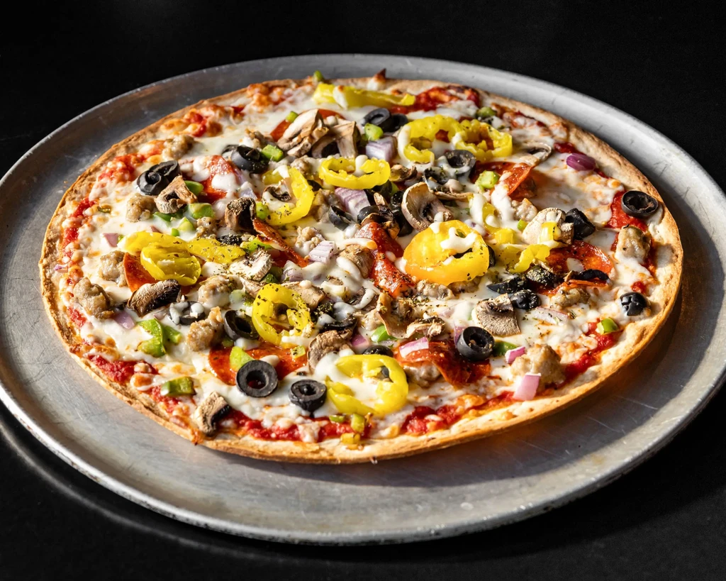 A well-topped pizza with pepperoni, sausage, olives, and banana peppers.