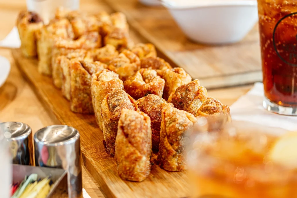 Golden brown crispy fried appetizers on a rustic wooden board.
