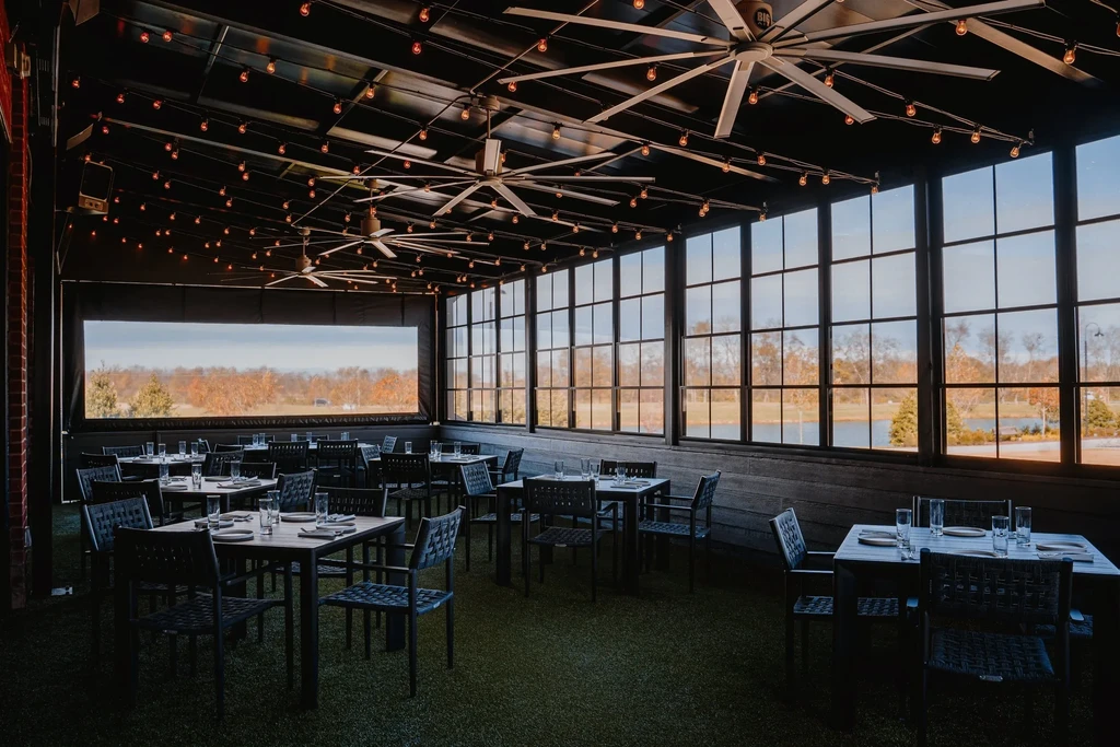 Empty contemporary dining room with turf floor and panoramic lake view.