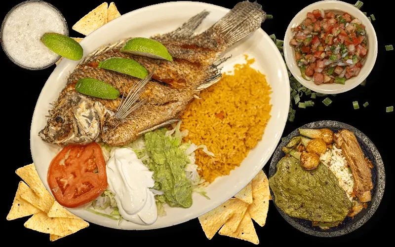 Mexican flat lay meal with fried fish, rice, guacamole, and horchata.
