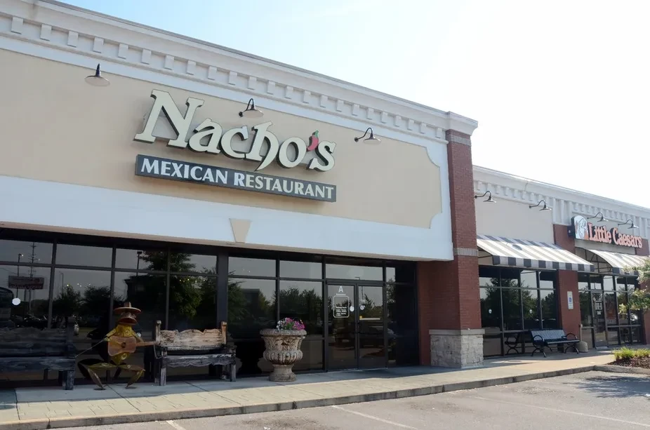 Nacho's Mexican Restaurant storefront with a frog statue in a strip mall.