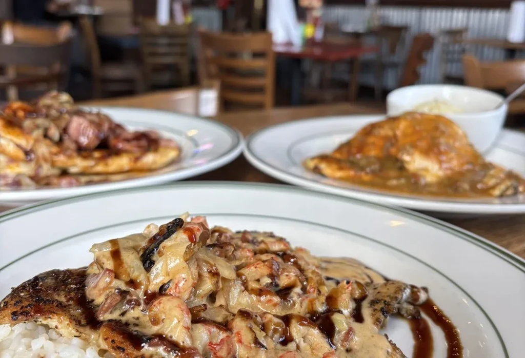 Close-up: pan-seared fish with creamy sauce, two blurred restaurant dishes.