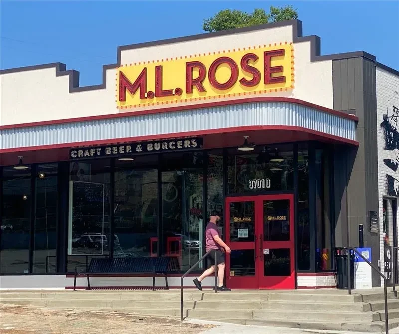 M.L. ROSE restaurant exterior with yellow sign; person walks to entrance.