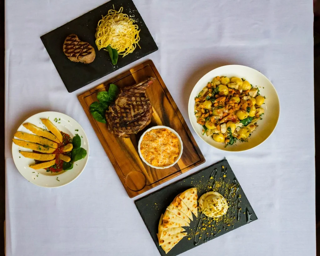 Overhead shot of a table with diverse, well-plated dishes.