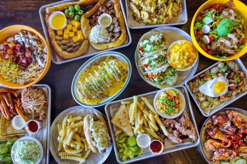 Top-down view of many diverse, abundant restaurant dishes on a table.