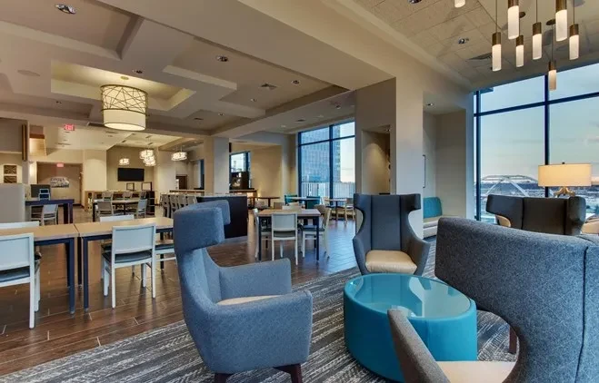 Sophisticated, modern lounge and dining area with blue armchairs.