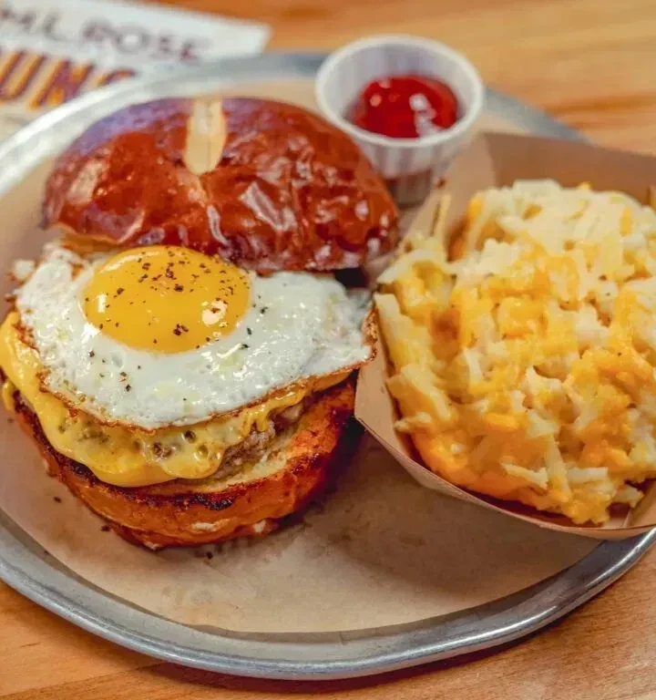 Breakfast burger with fried egg, melted cheese, and cheesy hash browns.