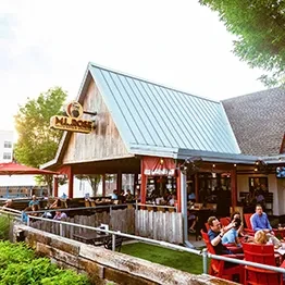 ML ROSE rustic restaurant with wooden building, blue roof, and outdoor diners.
