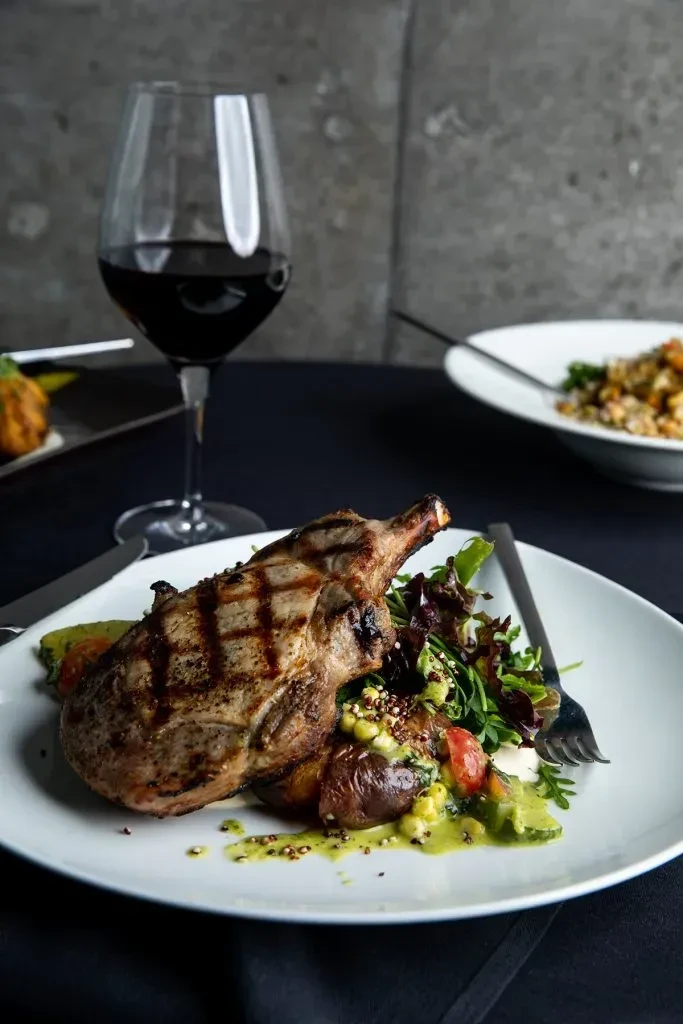 Grilled chop, mixed salad with potatoes, and red wine.