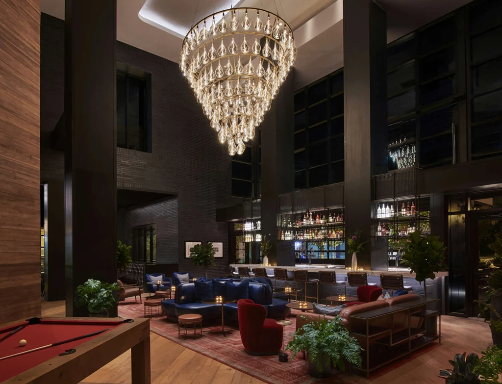 Spacious, luxurious lounge bar with chandelier, seating, and a pool table.
