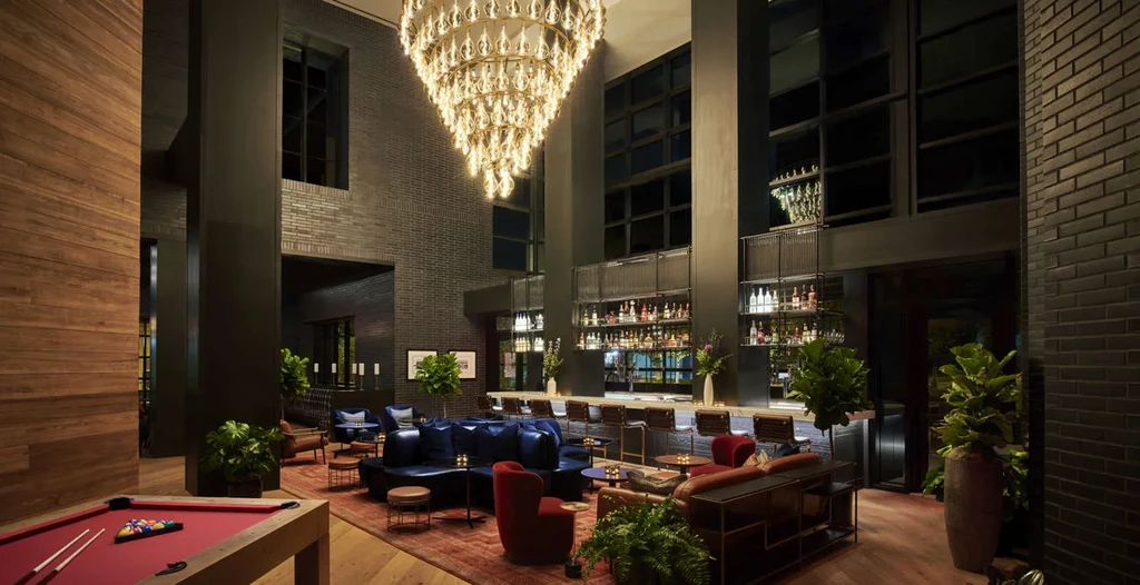 Luxury hotel bar and lounge with chandelier and pool table.
