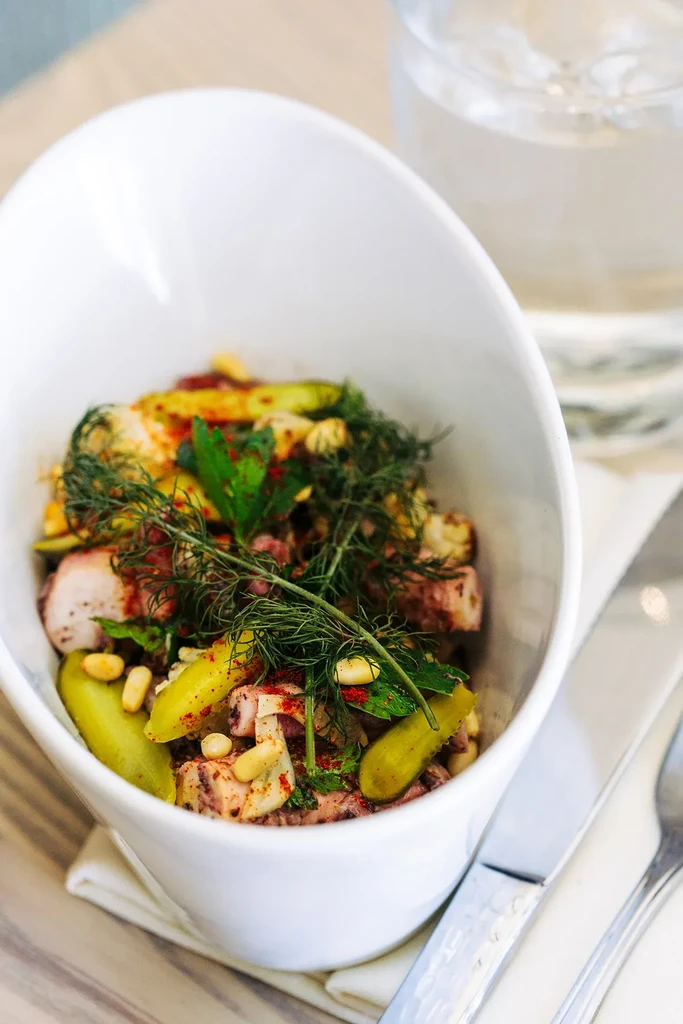 Vibrant seafood and pickled vegetable salad in a modern white bowl.