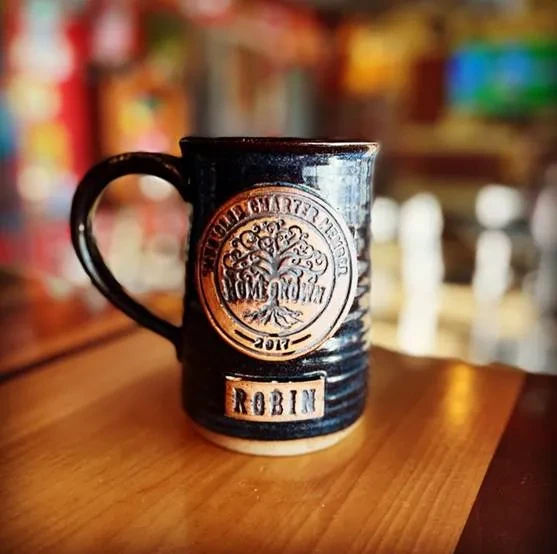 Dark textured ceramic mug with Old Quarter medallion and Robin plaque.