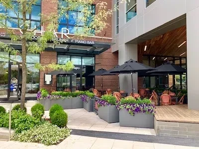 HAR restaurant patio with black umbrellas, grey planters, and purple flowers.