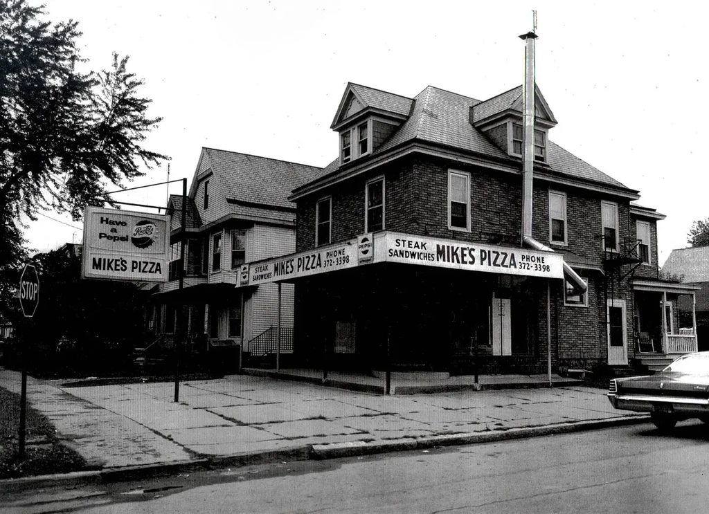 Vintage black and white photo of Mike's Pizza brick facade.