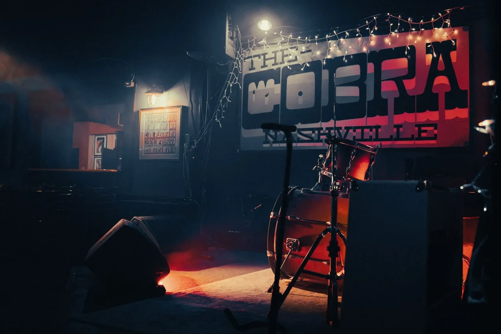 Stage with drum kit, microphone, and 'THE COBRA NASHVILLE' sign.
