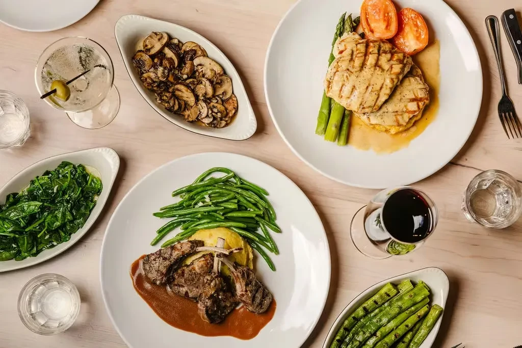 Top-down view of a dining table with various gourmet dishes and drinks.